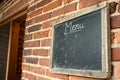 Aged Blackboard for Menu Ã¢â¬\' Hanging on Brick Wall Royalty Free Stock Photo